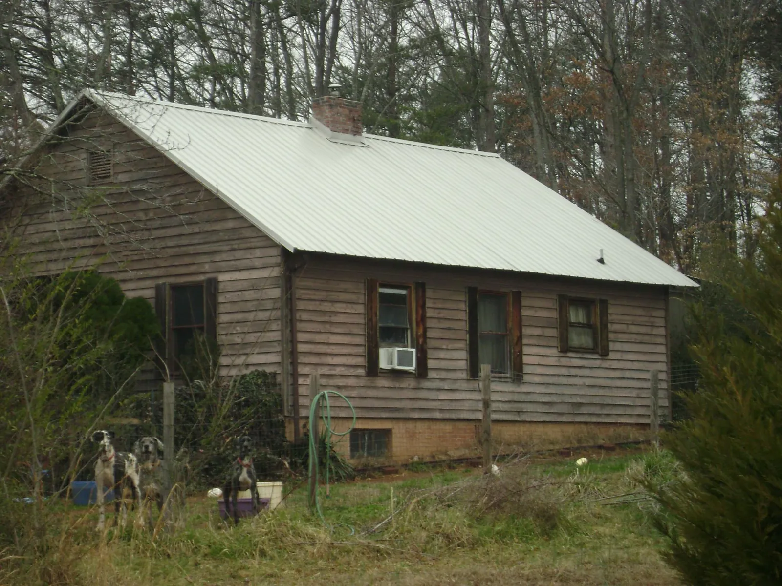 White metal roof on an old wood sided farmhouse, from a Metal Roof Installation job in Riverside
